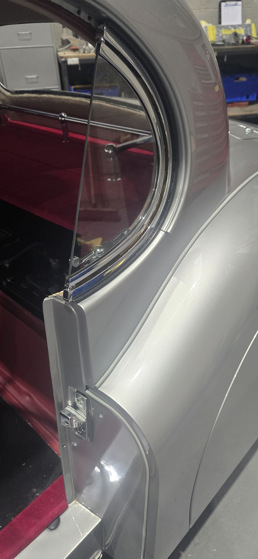 The XK120 Coupé's door open, showing the red interior