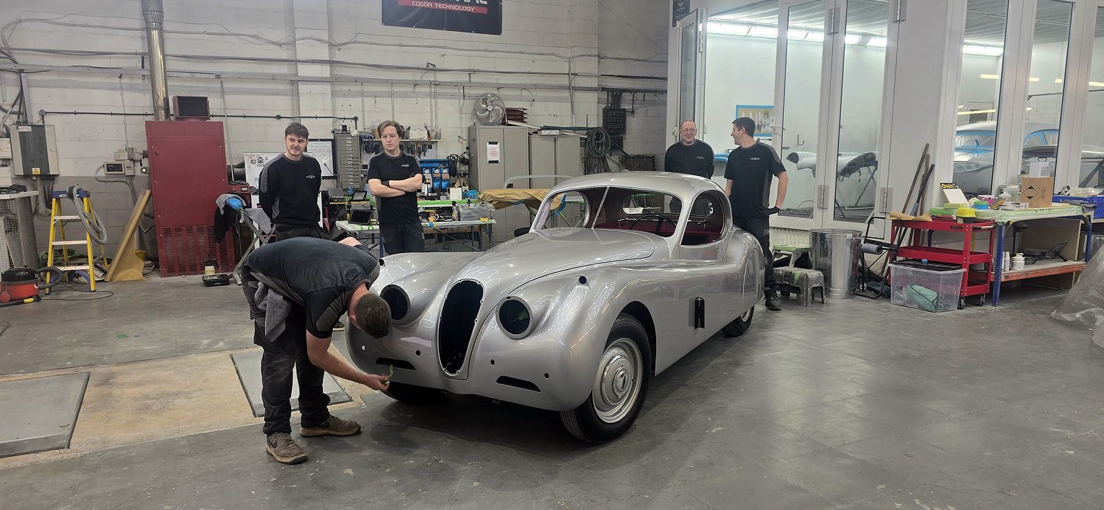 The Classic Workshop team gathered around the freshly painted XK120 Coupé