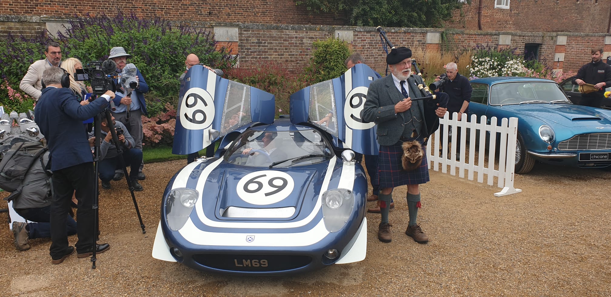The LM69 gull-wing doors raised with a bagpiper