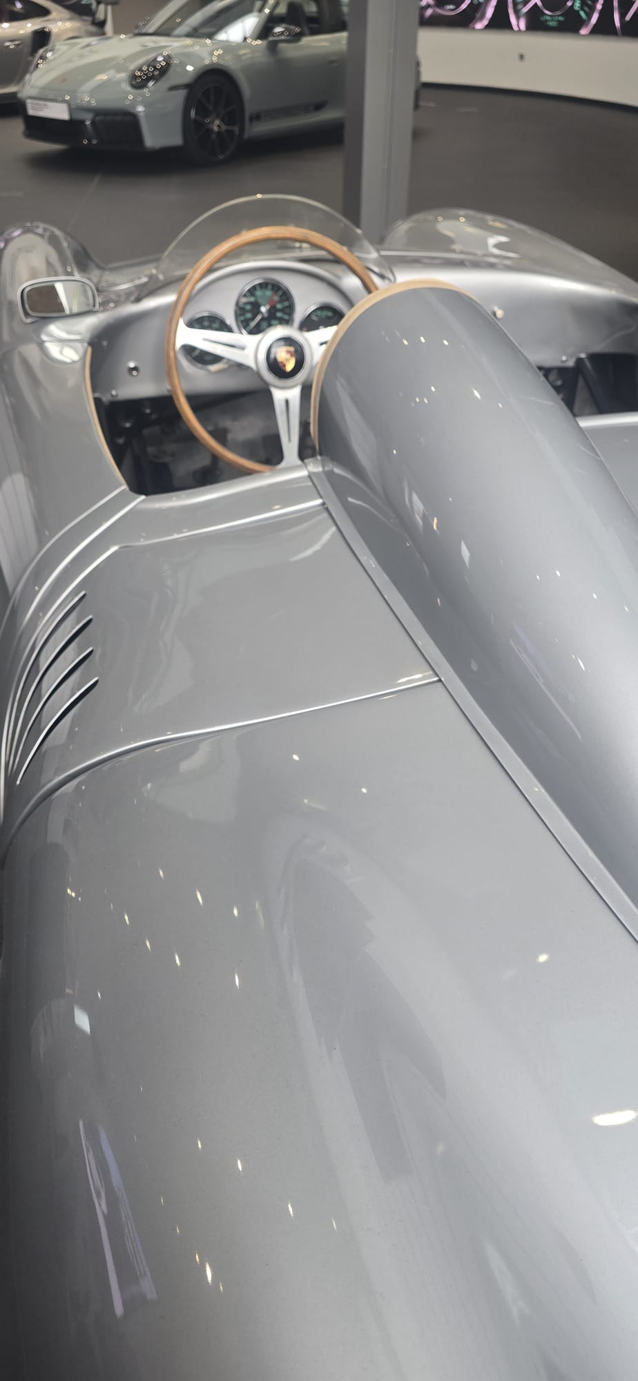 Wood-rimmed wheel behind the low windscreen